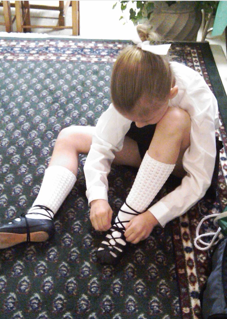 Young Addie lacing up her Irish dance shoes