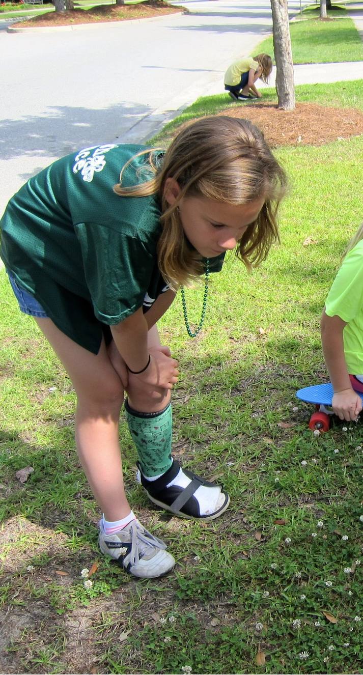Addie finding a clover in the grass as a girl