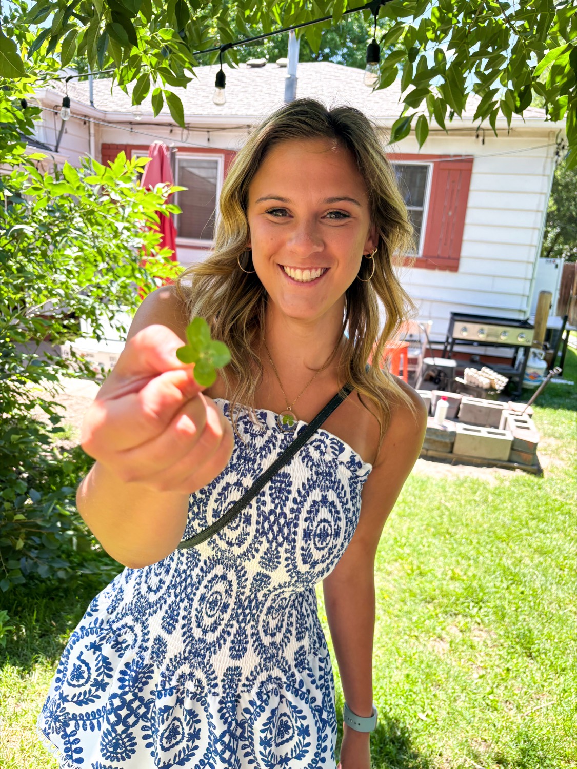 Addie, founder of Four Leaf Finds Co., holding a real four-leaf clover