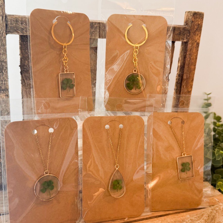 A clover necklace on a kraft card in a clear sleeve
